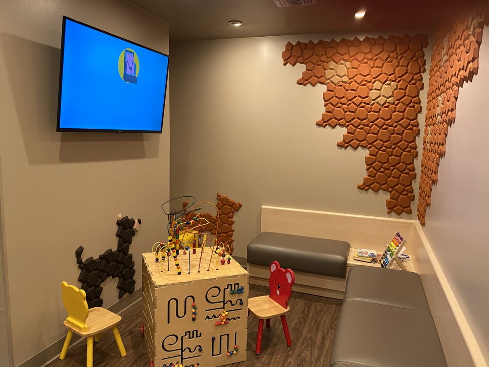 Cozy reading and play nook in the waiting room with a bead maze and kid-sized chairs